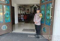 Anggota Polsek Buay Madang Timur, Brigadir Tedy Heryadi, berjaga di pintu masuk Gereja Trinitas Bangun Sari BK 3, Kecamatan Buay Madang Timur, Kabupaten OKU Timur. 