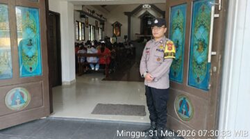 Anggota Polsek Buay Madang Timur, Brigadir Tedy Heryadi, berjaga di pintu masuk Gereja Trinitas Bangun Sari BK 3, Kecamatan Buay Madang Timur, Kabupaten OKU Timur. 