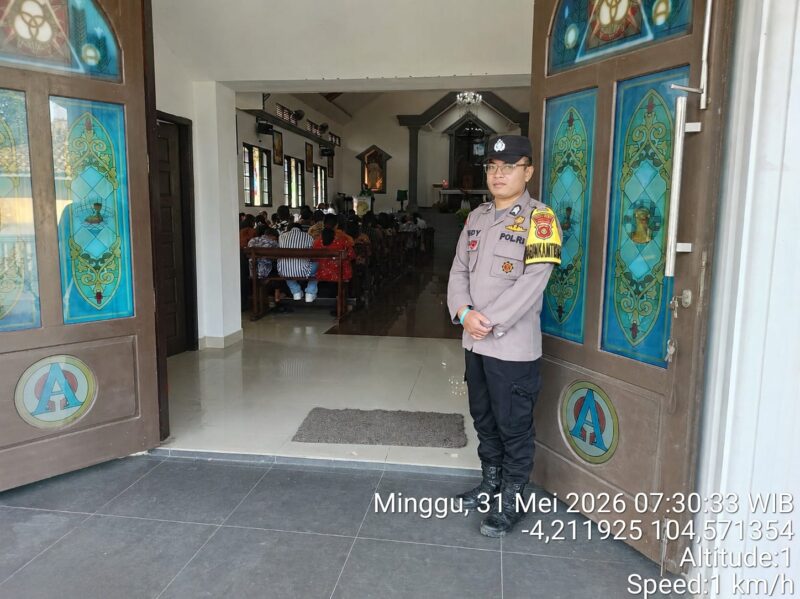 Anggota Polsek Buay Madang Timur, Brigadir Tedy Heryadi, berjaga di pintu masuk Gereja Trinitas Bangun Sari BK 3, Kecamatan Buay Madang Timur, Kabupaten OKU Timur. 