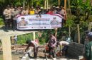 Kapolsek Buay Madang Timur Iptu Swisspo bersama personel kepolisian dan masyarakat membentangkan spanduk program 