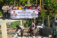 Kapolsek Buay Madang Timur Iptu Swisspo bersama personel kepolisian dan masyarakat membentangkan spanduk program "Bedah Rumah Polri Untuk Masyarakat" di lokasi pembangunan rumah Nurmala Sari, Desa Tugu Harum, Kecamatan Belitang Madang Raya, Kabupaten OKU Timur, Sumatera Selatan. 