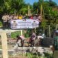 Kapolsek Buay Madang Timur Iptu Swisspo bersama personel kepolisian dan masyarakat membentangkan spanduk program 