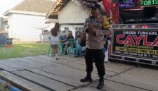 Bhabinkamtibmas Polsek Buay Madang Timur Bripka Nur Holik menyampaikan imbauan kamtibmas di atas panggung orgen tunggal saat menggelar operasi penertiban di Desa Gumuk Rejo, Kecamatan Buay Madang Timur, Kabupaten OKU Timur, Sumatera Selatan. 