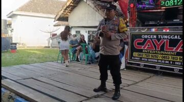 Bhabinkamtibmas Polsek Buay Madang Timur Bripka Nur Holik menyampaikan imbauan kamtibmas di atas panggung orgen tunggal saat menggelar operasi penertiban di Desa Gumuk Rejo, Kecamatan Buay Madang Timur, Kabupaten OKU Timur, Sumatera Selatan. 