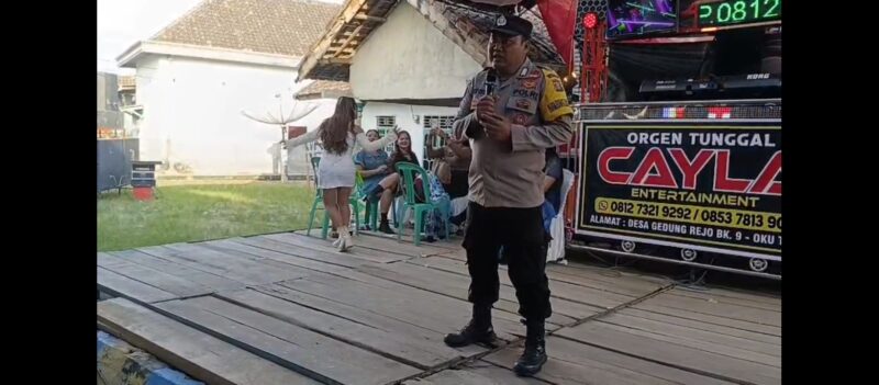 Bhabinkamtibmas Polsek Buay Madang Timur Bripka Nur Holik menyampaikan imbauan kamtibmas di atas panggung orgen tunggal saat menggelar operasi penertiban di Desa Gumuk Rejo, Kecamatan Buay Madang Timur, Kabupaten OKU Timur, Sumatera Selatan. 