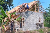 Sejumlah personel Polsek Buay Madang Timur bersama warga sekitar bergotong-royong memasang genteng pada rangka atap dalam program Bedah Rumah Polri Untuk Masyarakat di Desa Tugu Harum, Kecamatan Belitang Madang Raya, Kabupaten OKU Timur, Sumatera Selatan. 