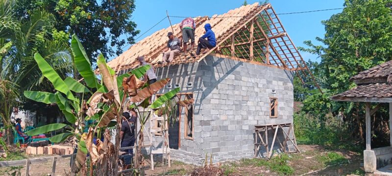 Sejumlah personel Polsek Buay Madang Timur bersama warga sekitar bergotong-royong memasang genteng pada rangka atap dalam program Bedah Rumah Polri Untuk Masyarakat di Desa Tugu Harum, Kecamatan Belitang Madang Raya, Kabupaten OKU Timur, Sumatera Selatan. 