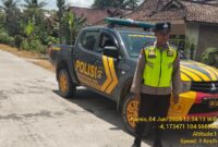 Personel Polsek Buay Madang Timur bersiaga di samping mobil dinas kepolisian saat melaksanakan Kegiatan Rutin Yang Ditingkatkan (KRYD) di Jalan Desa Sukoharjo, Kecamatan Buay Madang Timur, Kabupaten OKU Timur, Sumatera Selatan. 