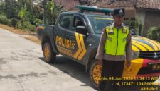 Personel Polsek Buay Madang Timur bersiaga di samping mobil dinas kepolisian saat melaksanakan Kegiatan Rutin Yang Ditingkatkan (KRYD) di Jalan Desa Sukoharjo, Kecamatan Buay Madang Timur, Kabupaten OKU Timur, Sumatera Selatan. 