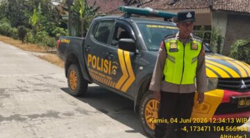 Personel Polsek Buay Madang Timur bersiaga di samping mobil dinas kepolisian saat melaksanakan Kegiatan Rutin Yang Ditingkatkan (KRYD) di Jalan Desa Sukoharjo, Kecamatan Buay Madang Timur, Kabupaten OKU Timur, Sumatera Selatan. 