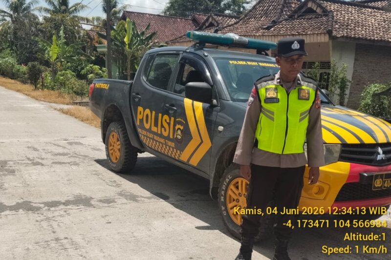 Personel Polsek Buay Madang Timur bersiaga di samping mobil dinas kepolisian saat melaksanakan Kegiatan Rutin Yang Ditingkatkan (KRYD) di Jalan Desa Sukoharjo, Kecamatan Buay Madang Timur, Kabupaten OKU Timur, Sumatera Selatan. 