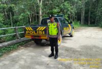Personel Polsek Buay Madang Timur bersiaga di samping kendaraan dinas saat menggelar patroli Kegiatan Rutin Yang Ditingkatkan (KRYD) di kawasan Jalan Desa Sumber Mulyo, Kecamatan Buay Madang Timur, Kabupaten OKU Timur. 