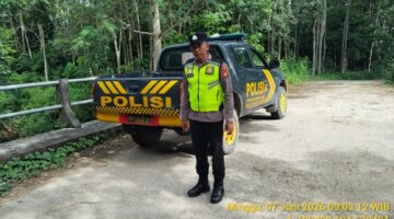Personel Polsek Buay Madang Timur bersiaga di samping kendaraan dinas saat menggelar patroli Kegiatan Rutin Yang Ditingkatkan (KRYD) di kawasan Jalan Desa Sumber Mulyo, Kecamatan Buay Madang Timur, Kabupaten OKU Timur. 