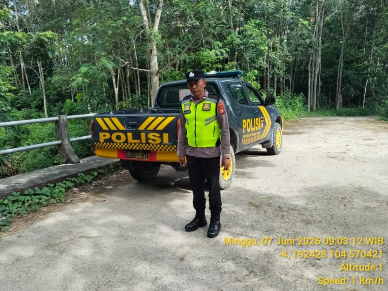 Personel Polsek Buay Madang Timur bersiaga di samping kendaraan dinas saat menggelar patroli Kegiatan Rutin Yang Ditingkatkan (KRYD) di kawasan Jalan Desa Sumber Mulyo, Kecamatan Buay Madang Timur, Kabupaten OKU Timur. 