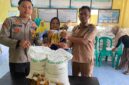  Polsek Buay Madang Timur Bripda Dekya Kevin Titara (kiri) bersama perangkat Desa Tambak Boyo (kanan) menyerahkan bantuan sosial berupa beras dan minyak goreng secara simbolis kepada salah satu warga penerima manfaat di Desa Tambak Boyo, Kecamatan Buay Madang Timur, Kabupaten OKU Timur. 