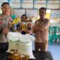  Polsek Buay Madang Timur Bripda Dekya Kevin Titara (kiri) bersama perangkat Desa Tambak Boyo (kanan) menyerahkan bantuan sosial berupa beras dan minyak goreng secara simbolis kepada salah satu warga penerima manfaat di Desa Tambak Boyo, Kecamatan Buay Madang Timur, Kabupaten OKU Timur. 