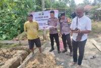 Kasium Polsek Buay Madang Timur Aipda Robbiansyah (kedua kiri) bersama Bhabinkamtibmas Brigadir Rusendi Ardianto (kedua kanan) dan Kepala Desa Berasan Mulya Pardiyono (kanan) memeriksa berkas rencana pembangunan saat meninjau titik nol proyek MCK dan Sumur Bor di lingkungan Masjid Al-Amin, Desa Berasan Mulya, Kecamatan Buay Madang Timur, Kabupaten OKU Timur. 