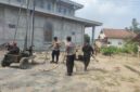 Kapolsek Buay Madang Timur IPTU Swisspo (tengah) memegang selang pembuangan air bersama personel Polsek saat meninjau langsung proses pengeboran sumur bor di samping Masjid Al-Amin, Desa Berasan Mulya, Kecamatan Buay Madang Timur, Kabupaten OKU Timur. 