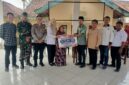 Kepala Desa Kedung Rejo, M Ahmad Asodikin (kelima kanan), menyerahkan bantuan secara simbolis kepada perwakilan warga lansia penerima manfaat disaksikan oleh Bhabinkamtibmas Polsek Buay Madang Timur Brigadir Tedy Heryadi (ketiga kiri) dan Babinsa Sertu Handoko (kedua kiri) di Balai Desa Kedung Rejo, Kecamatan Buay Madang Timur, Kabupaten OKU Timur. 