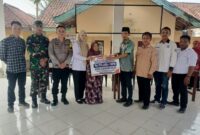 Kepala Desa Kedung Rejo, M Ahmad Asodikin (kelima kanan), menyerahkan bantuan secara simbolis kepada perwakilan warga lansia penerima manfaat disaksikan oleh Bhabinkamtibmas Polsek Buay Madang Timur Brigadir Tedy Heryadi (ketiga kiri) dan Babinsa Sertu Handoko (kedua kiri) di Balai Desa Kedung Rejo, Kecamatan Buay Madang Timur, Kabupaten OKU Timur. 