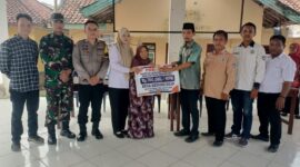 Kepala Desa Kedung Rejo, M Ahmad Asodikin (kelima kanan), menyerahkan bantuan secara simbolis kepada perwakilan warga lansia penerima manfaat disaksikan oleh Bhabinkamtibmas Polsek Buay Madang Timur Brigadir Tedy Heryadi (ketiga kiri) dan Babinsa Sertu Handoko (kedua kiri) di Balai Desa Kedung Rejo, Kecamatan Buay Madang Timur, Kabupaten OKU Timur. 