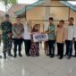 Kepala Desa Kedung Rejo, M Ahmad Asodikin (kelima kanan), menyerahkan bantuan secara simbolis kepada perwakilan warga lansia penerima manfaat disaksikan oleh Bhabinkamtibmas Polsek Buay Madang Timur Brigadir Tedy Heryadi (ketiga kiri) dan Babinsa Sertu Handoko (kedua kiri) di Balai Desa Kedung Rejo, Kecamatan Buay Madang Timur, Kabupaten OKU Timur. 