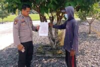 Personel Polsek Buay Madang Timur Aipda Zulkifli (kiri) menunjukan lembar Maklumat Kapolda Sumsel tentang larangan membakar hutan dan lahan kepada seorang warga di Desa Karang Tengah, Kecamatan Buay Madang Timur, Kabupaten OKU Timur, Sumatera Selatan. 