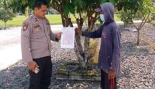 Personel Polsek Buay Madang Timur Aipda Zulkifli (kiri) menunjukan lembar Maklumat Kapolda Sumsel tentang larangan membakar hutan dan lahan kepada seorang warga di Desa Karang Tengah, Kecamatan Buay Madang Timur, Kabupaten OKU Timur, Sumatera Selatan.