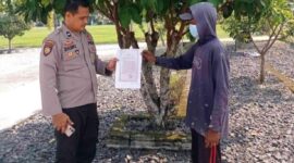 Personel Polsek Buay Madang Timur Aipda Zulkifli (kiri) menunjukan lembar Maklumat Kapolda Sumsel tentang larangan membakar hutan dan lahan kepada seorang warga di Desa Karang Tengah, Kecamatan Buay Madang Timur, Kabupaten OKU Timur, Sumatera Selatan. 