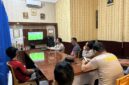 Jajaran personel Polsek Buay Madang Timur bersama warga sekitar membaur menyaksikan siaran langsung pertandingan babak penyisihan Piala Dunia 2026 antara Qatar vs Swiss di ruang pertemuan Mako Polsek Buay Madang Timur, Kabupaten OKU Timur, Sumatra Selatan. 