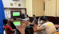 Jajaran personel Polsek Buay Madang Timur bersama warga sekitar membaur menyaksikan siaran langsung pertandingan babak penyisihan Piala Dunia 2026 antara Qatar vs Swiss di ruang pertemuan Mako Polsek Buay Madang Timur, Kabupaten OKU Timur, Sumatra Selatan. 