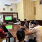 Jajaran personel Polsek Buay Madang Timur bersama warga sekitar membaur menyaksikan siaran langsung pertandingan babak penyisihan Piala Dunia 2026 antara Qatar vs Swiss di ruang pertemuan Mako Polsek Buay Madang Timur, Kabupaten OKU Timur, Sumatra Selatan. 