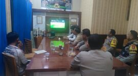 Sejumlah personel Polsek Buay Madang Timur bersama warga menyaksikan siaran langsung pertandingan Prancis vs Senegal dalam acara nonton bareng Pesta Bola Dunia 2026 di Mako Polsek Buay Madang Timur, Kabupaten OKU Timur, Sumatra Selatan. 