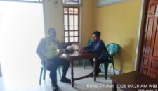 Personel Polsek Buay Madang Timur, Bripka Nur Holik (kiri), berdialog dengan perangkat desa saat melaksanakan kegiatan sambang dan silaturahmi di Kantor Desa Kedu, Kecamatan Buay Madang Timur, Kabupaten OKU Timur, Sumatra Selatan. 