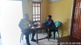 Personel Polsek Buay Madang Timur, Bripka Nur Holik (kiri), berdialog dengan perangkat desa saat melaksanakan kegiatan sambang dan silaturahmi di Kantor Desa Kedu, Kecamatan Buay Madang Timur, Kabupaten OKU Timur, Sumatra Selatan. 