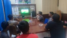 Kapolsek Buay Madang Timur Iptu Swisspo, bersama personel dan warga pencinta sepak bola saat menyaksikan pertandingan Pesta Bola Dunia 2026 antara Swiss vs Bosnia di ruang pertemuan Mako Polsek Buay Madang Timur, OKU Timur.