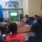 Kapolsek Buay Madang Timur Iptu Swisspo, bersama personel dan warga pencinta sepak bola saat menyaksikan pertandingan Pesta Bola Dunia 2026 antara Swiss vs Bosnia di ruang pertemuan Mako Polsek Buay Madang Timur, OKU Timur. 