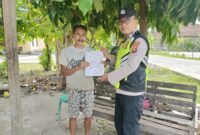 Personil Polsek Buay Madang Timur menyerahkan lembaran Maklumat Kapolda Sumsel tentang larangan membakar hutan dan lahan kepada salah seorang warga saat menggelar patroli dialogis di Kecamatan Buay Madang Timur, Kabupaten OKU Timur. 
