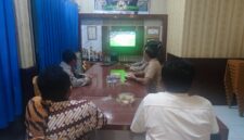 Kapolsek Buay Madang Timur Iptu Swisspo, bersama personel dan warga setempat menyaksikan pertandingan laga Pesta Bola Dunia 2026 antara Amerika Serikat melawan Australia di Mako Polsek Buay Madang Timur, Kabupaten OKU Timur.