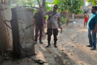 Anggota Polsek Buay Madang Timur, Polres OKU Timur, memeriksa kondisi selang dan mesin pengisian BBM Pertamini yang hangus terbakar di depan sebuah toko sembako di Desa Banyumas Asri, Kecamatan Buay Madang Timur, OKU Timur. 
