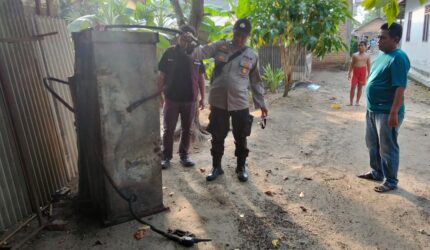 Anggota Polsek Buay Madang Timur, Polres OKU Timur, memeriksa kondisi selang dan mesin pengisian BBM Pertamini yang hangus terbakar di depan sebuah toko sembako di Desa Banyumas Asri, Kecamatan Buay Madang Timur, OKU Timur.