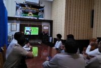 Kapolsek Buay Madang Timur IPTU Swisspo, bersama jajaran personel dan warga pencinta sepak bola menyaksikan pertandingan Portugal vs Uzbekistan saat acara Nonton Bareng (Nobar) Pesta Bola Dunia 2026 di Mako Polsek Buay Madang Timur, Kabupaten OKU Timur. 