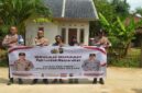 Kapolsek Buay Madang Timur Iptu Swisspo, bersama jajaran personel, perangkat desa, serta warga penerima manfaat, Nurmala Sari, membentangkan spanduk di depan rumah yang telah selesai dibedah di Desa Tugu Harum, Kecamatan Belitang Madang Raya, Kabupaten OKU Timur, Sumatera Selatan. 