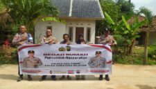 Kapolsek Buay Madang Timur Iptu Swisspo, bersama jajaran personel, perangkat desa, serta warga penerima manfaat, Nurmala Sari, membentangkan spanduk di depan rumah yang telah selesai dibedah di Desa Tugu Harum, Kecamatan Belitang Madang Raya, Kabupaten OKU Timur, Sumatera Selatan. 