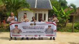 Kapolsek Buay Madang Timur Iptu Swisspo, bersama jajaran personel, perangkat desa, serta warga penerima manfaat, Nurmala Sari, membentangkan spanduk di depan rumah yang telah selesai dibedah di Desa Tugu Harum, Kecamatan Belitang Madang Raya, Kabupaten OKU Timur, Sumatera Selatan. 