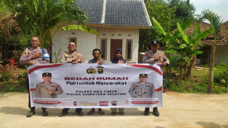 Kapolsek Buay Madang Timur Iptu Swisspo, bersama jajaran personel, perangkat desa, serta warga penerima manfaat, Nurmala Sari, membentangkan spanduk di depan rumah yang telah selesai dibedah di Desa Tugu Harum, Kecamatan Belitang Madang Raya, Kabupaten OKU Timur, Sumatera Selatan. 