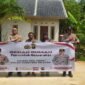 Kapolsek Buay Madang Timur Iptu Swisspo, bersama jajaran personel, perangkat desa, serta warga penerima manfaat, Nurmala Sari, membentangkan spanduk di depan rumah yang telah selesai dibedah di Desa Tugu Harum, Kecamatan Belitang Madang Raya, Kabupaten OKU Timur, Sumatera Selatan. 