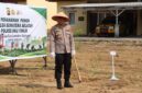 Kapolres OKU Timur AKBP Adik Listiyono, berdiri di samping spanduk bertuliskan 