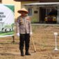 Kapolres OKU Timur AKBP Adik Listiyono, berdiri di samping spanduk bertuliskan 