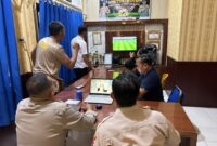 Jajaran personel Polsek Buay Madang Timur bersama masyarakat pencinta sepak bola menyaksikan pertandingan laga Norwegia melawan Perancis saat nonton bareng Pesta Bola Dunia 2026 di Mako Polsek Buay Madang Timur, OKU Timur. 